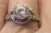 Top view of the sterling silver ring showcasing the large round clear cubic zirconia center stone surrounded by smaller CZ stones.