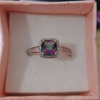 Front view of sterling silver ring with a multicolored cushion-cut Mystic Topaz gemstone centered in a halo of small stones.