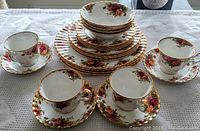 Photo showing complete place settings for four with all plates, bowls, cups, and saucers visible.