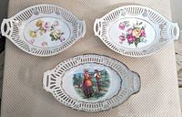 Set of three German porcelain baskets with pierced edge detail and gilt accents on cloth background
