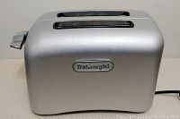 Full left side view of the silver DeLonghi toaster showing two bread slots and the brand name