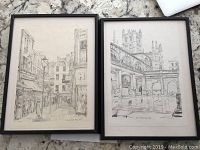 Two black and white city street and architectural prints of Bath in black frames.