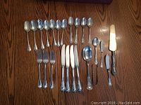 Full assortment of flatware and accessories laid out on wood table