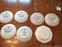 Back view of all seven decorative plates showing brands and markings