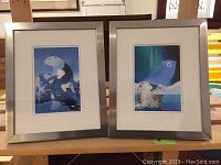 Pair of two framed polar bear prints shown side by side on a wooden surface