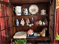 Three-shelf cabinet display with all porcelain and ceramic items arranged