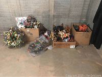 Boxes and loose items containing assorted Easter and Halloween decorations and wreaths seen from front view