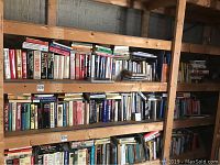Two wooden shelves filled with books of various genres and subjects.