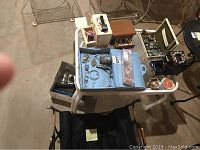 Overview of costume jewelry, jewelry boxes, and watches on white table