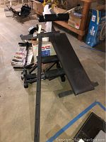 Top view of black padded adjustable weight bench with metal frame and support bars