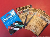 Photo presenting the Ultimate Dining Card and the three guest passes together on a red surface.