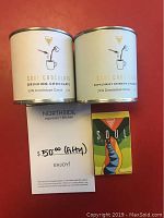 Photo showing two cans of Soul Chocolate Drinking Chocolate, one plain and one peppermint, alongside a Soul Chocolate bar and the $50 gift certificate for Northside Espresso + Kitchen.