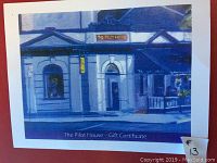 Photo showing the printed gift certificate with an artistic image of The Pilot House restaurant exterior and the gift certificate text.