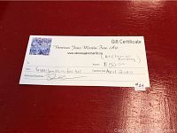Photo of the $50 Vanessa Jane Martin Fine Art gift certificate on a red surface, showing handwritten amount, expiration date April 2020, and signature.