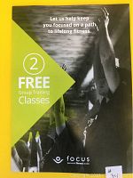 Front side of voucher showing 2 free group training classes at Focus Fitness with a black and white photo of participants exercising