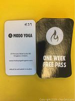 Front and back of one week free pass cards showing branding, logo, terms and studio address