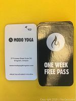 Front and back of the one-week free pass cards laid on yellow background