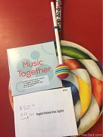 Colorful hand drum with painted abstract swirl design, wooden mallet with striped ball tip; Music Together 8-song welcome CD cover and $50 gift card shown