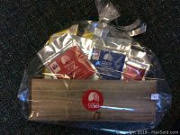 Photo of a gift basket wrapped in cellophane containing a wooden crate with assorted packets of Coco Chocolate Organic Dark Chocolate products.