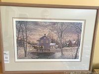 Framed print showing a winter scene with a horse and carriage in front of houses.