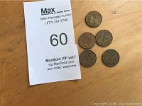 Photo of six Canadian 5-cent coins dated 1943 alongside an auction lot card.