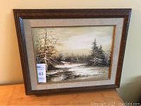 Full view of the framed oil painting illustrating the winter landscape scene with trees, cabin, and snowy ground.