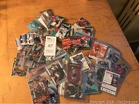 Large pile of hockey cards in individual plastic cases spread on wood surface