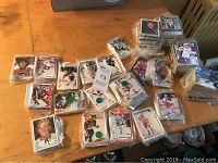 Top view of the table revealing multiple stacks and bagged sets of hockey cards, some with player images and partial team logos visible.