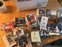 Stacks of hockey cards in multiple plastic bags and some out for display on a table, showing player images and holographic cards.