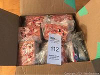 Open cardboard box containing 13 plastic bag sets of hockey trading cards with red and white player images on the front.