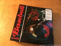 Black album with 'Baseball Cards Album' title and vintage baseball equipment image on cover, with lot sticker.