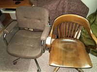 View of both office chairs side by side, showing upholstery condition and wood finish wear.