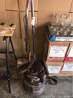 Full view showing the vacuum canister with attached hose and upright wand.