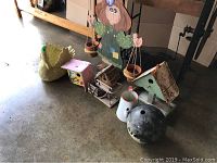 Overview of all items including wooden plant holder, birdhouses, swan planter, watering can, and bowling ball on floor