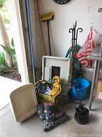 Wide view photo showing commercial dolly, metal lamp base, crate of cables and extension cord, pair of roller blades