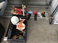 Overview photo showing Star Trek dolls and other dolls arranged on a metal shelf above black crate with spaceship toys inside.