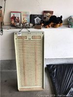 Full view of pet step dog ramp with dog books, plush toys, photo album and food bowls placed on white surface above.