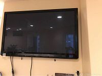 Front view of wall-mounted Panasonic TV showing screen and bezel