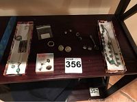 Overview of all jewelry pieces including necklaces, rings, and earrings displayed on a dark surface with boxes.