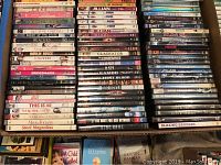 Photo showing 90 DVDs stacked in rows with visible titles across genres