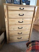 Front view of the contemporary chest of drawers with six drawers and metal handles.