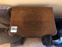 Top-down view showing wood grain and surface wear on the top panel of the jewelry case.