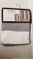 Photo of Darcy Rod Pocket Panel label with size options 52 x 63 inches and 52 x 84 inches, showing a folded curtain with gray and white horizontal stripes
