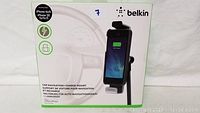 Box front showing Belkin branding and image of the phone mount holding and charging an iPhone 6s/6.