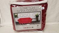Front view of the packaged Monica stretch sofa slip cover in red, labeled with size and brand.