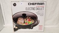 Box front showing the Chefman 12-inch round electric skillet with cooked food in the pan.