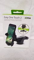 Front of the product box showing iOttie Easy One Touch 2 phone mount and a phone mounted on it.