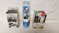 Lot overview with all three items: two universal car phone mounts and one Bluetooth headset in original packaging