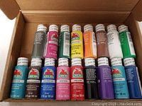 Box of 17 Apple Barrel matte acrylic paint bottles in various colors arranged in a cardboard box.