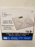 Box front showing Mainstays Super Slim Digital Scale and key dimensions: 11.89 in width and depth, 0.67 in height